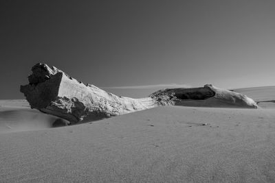 Scenic view of rocks on shore against clear sky