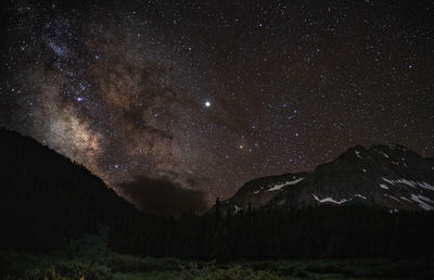 Scenic view of mountains against star field at night