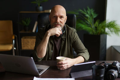 Young man using mobile phone while sitting on table