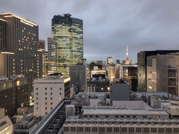 Buildings in city against cloudy sky