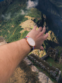 High angle view of man hand on rock