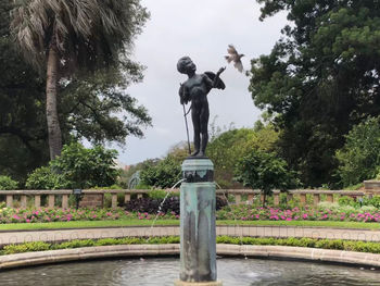 Statue in park against sky