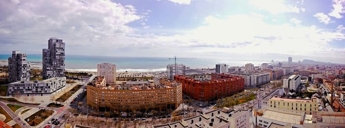 View of cityscape against cloudy sky