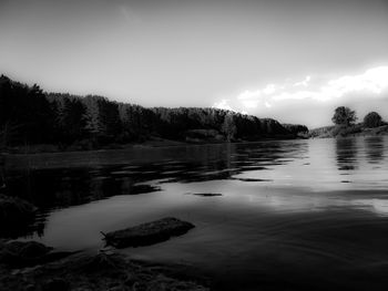 Scenic view of lake in forest against sky