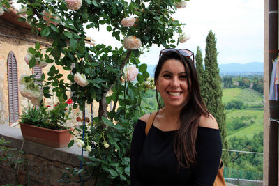 Portrait of young woman standing against plants