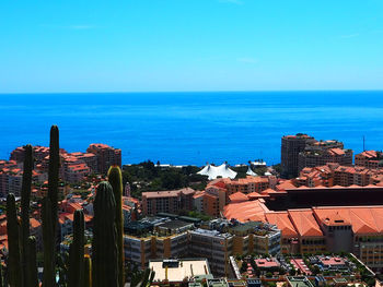 High angle view of buildings by sea against clear sky
