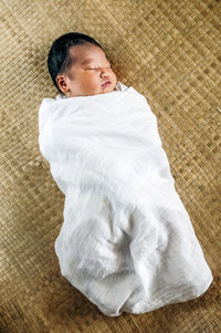 High angle view of baby boy sleeping on bed