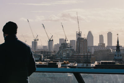 Rear view of man standing against cityscape