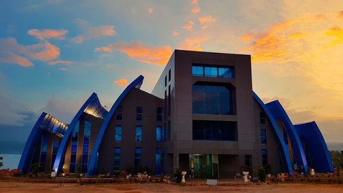 Low angle view of modern building against sky during sunset