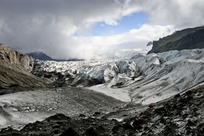 Scenic view of mountains against cloudy sky