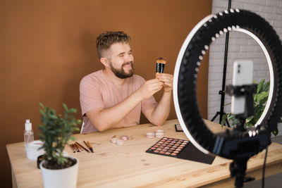 Young man using mobile phone on table