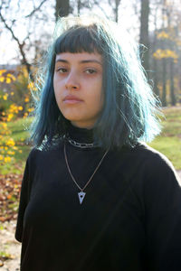 Close-up portrait of young woman with dyed hair at park