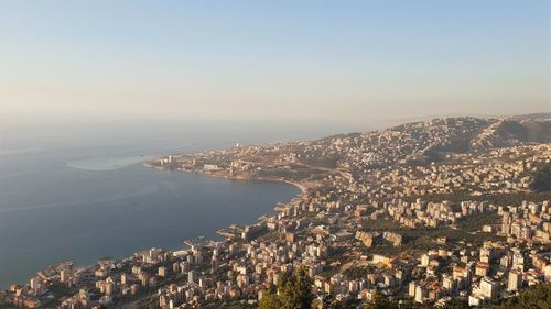 High angle view of townscape by sea against sky