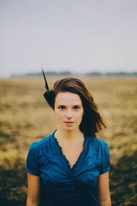 Portrait of young woman standing on field