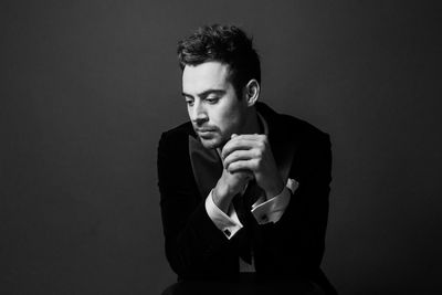 Portrait of young man against black background