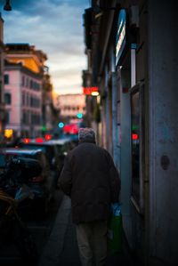 Rear view of man walking on city street