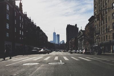 Road leading towards one world trade center against sky in city
