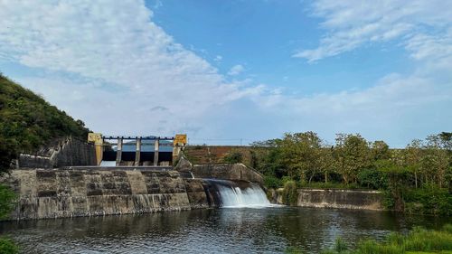 View of dam by river against sky