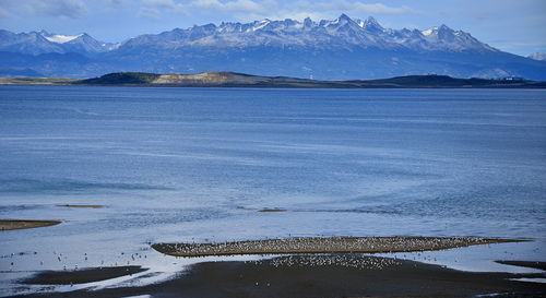 Scenic view of lake and snowcapped mountains against sky