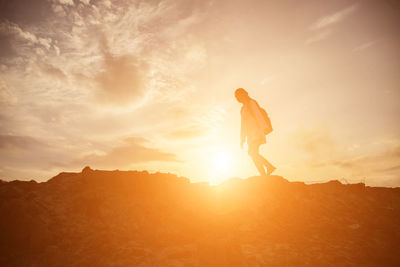 Man standing on mountain against sky during sunset