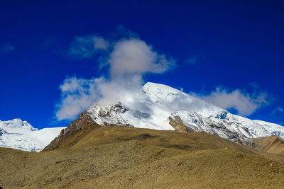 Scenic view of snowcapped mountains against blue sky