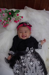 Portrait of cute baby girl on bed at home