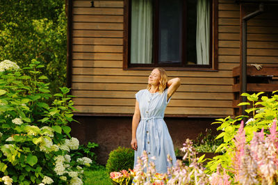 Woman standing by potted plants