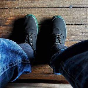 Low section of man sitting on hardwood floor