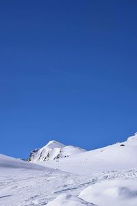 Scenic view of snowcapped mountains against clear blue sky