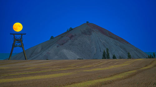 Scenic view of desert against clear blue sky