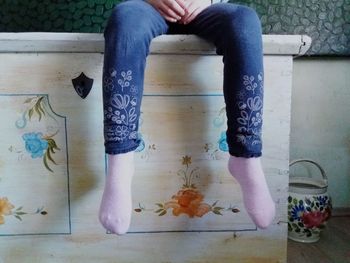 Low section of woman sitting on floor at home