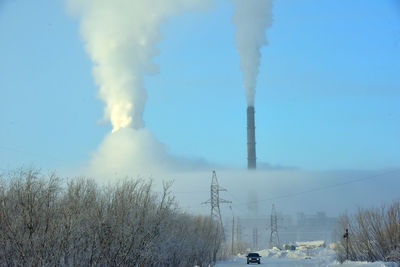 Smoke emitting from chimney against sky