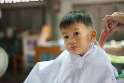 Cute boy sitting at barber shop