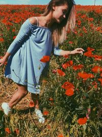 Full length of woman with flowers on field