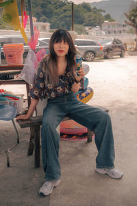 Portrait of young woman sitting on street