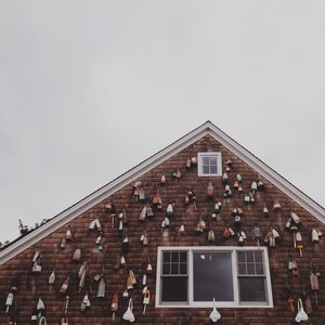 Group of objects on high section of house against clear sky