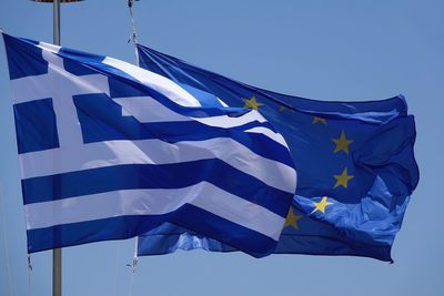 Low angle view of flags against clear blue sky