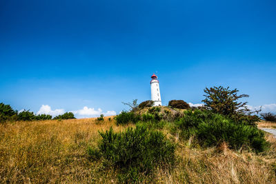 Lighthouse on field against sky