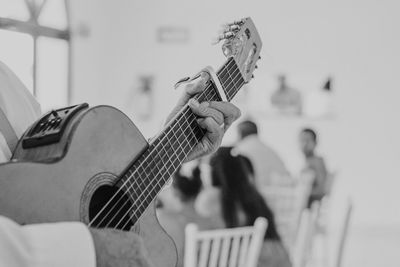 Cropped image of musician playing guitar at beach