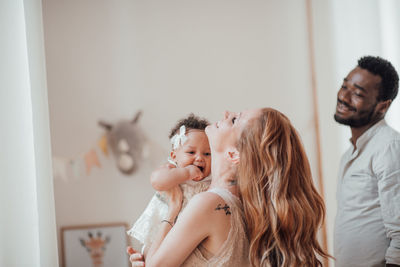 Happy mother and daughter against wall