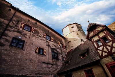 Low angle view of old building in town against sky