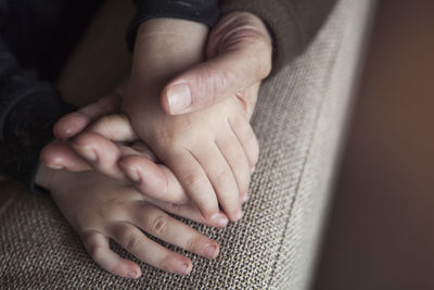 Close-up of parent holding child hand