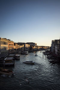 View of river and buildings against clear sky