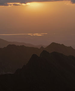 Scenic view of silhouette mountains against sky during sunset