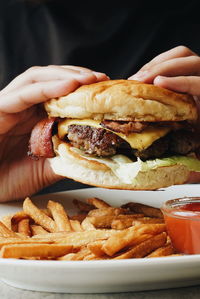 Close-up of cropped hands having burger