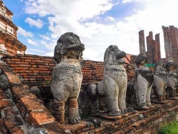 Statue against old wall against sky