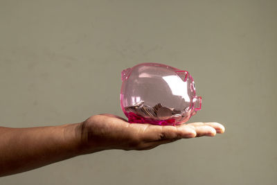 Close-up of hand holding glass against white background