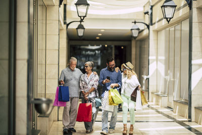 Family with shopping bags walking in illuminated building