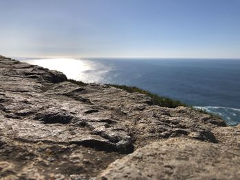 Scenic view of rocks on beach against sky