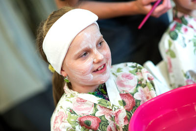 Close-up of girl with facial mask sitting in spa